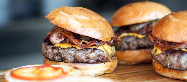 cheeseburgers with bacon and yellow cheese and extra buns with ketchup and mustard