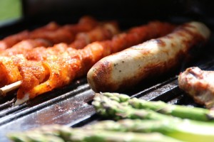 sausages, asparagus spears, and meat on a hot grill