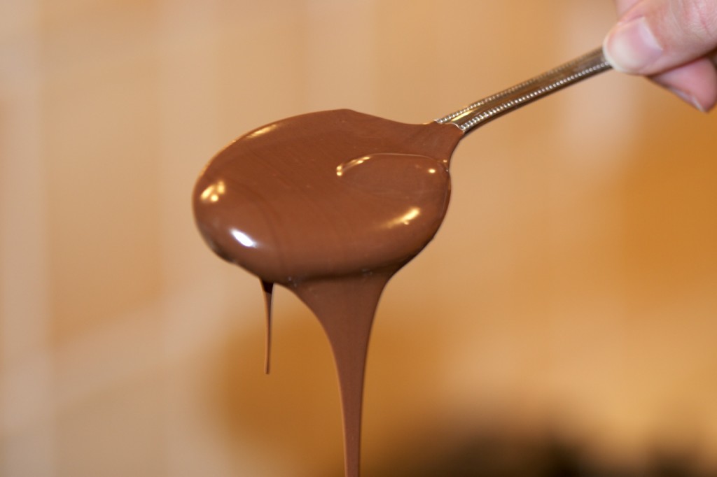 Melted milk chocolate on a spoon, dripping